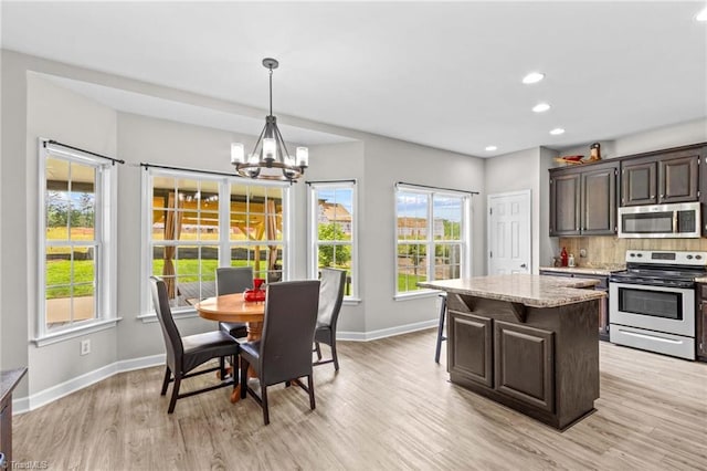 159 Forest Abbey Ln, China Grove, NC 28023 - kitchen with appliances with stainless steel finishes, a chandelier, light wood-type flooring, a center island, and healthy amount of natural light