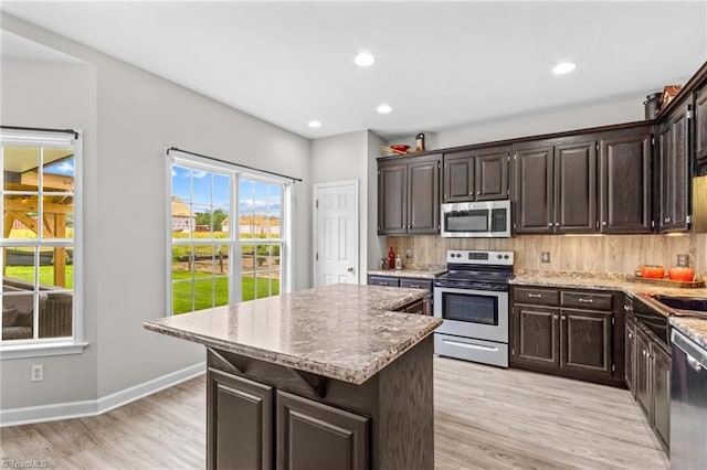 159 Forest Abbey Ln, China Grove, NC 28023 - kitchen with appliances with stainless steel finishes, light wood-style flooring, a center island, dark brown cabinetry, and recessed lighting