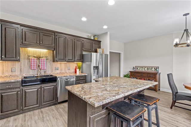 159 Forest Abbey Ln, China Grove, NC 28023 - kitchen featuring stainless steel appliances, a center island, light wood-style floors, a breakfast bar area, and recessed lighting