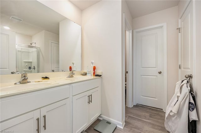 bathroom featuring vanity, walk in shower, and wood-type flooring