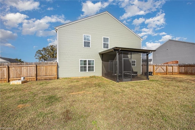 rear view of property featuring a yard and a sunroom