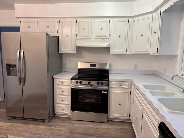 1427 Westwood Ln, Wilkesboro, NC 28697 - kitchen featuring appliances with stainless steel finishes, a sink, under cabinet range hood, wood finished floors, and light countertops