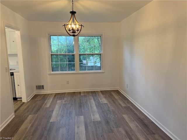 1427 Westwood Ln, Wilkesboro, NC 28697 - unfurnished dining area with a chandelier, dark wood finished floors, and baseboards