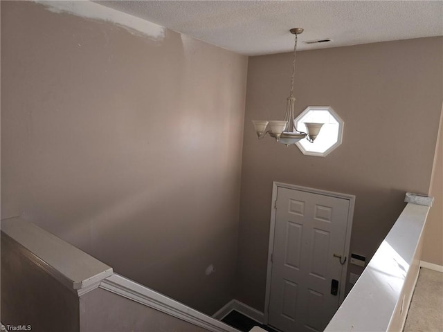 entrance foyer featuring a textured ceiling, visible vents, and baseboards