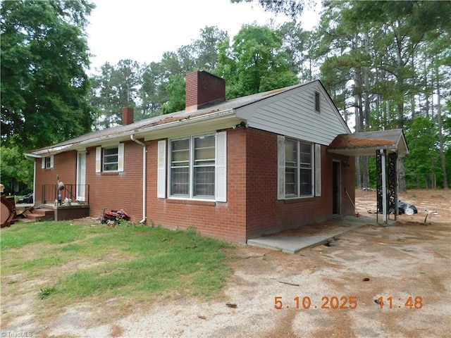 314 S Mccallum St, Candor, NC 27229 - view of side of property featuring a chimney, brick siding, and a patio area