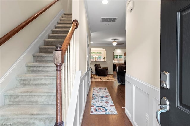 stairway featuring ceiling fan and hardwood / wood-style floors