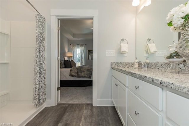 full bathroom featuring ensuite bath, vanity, a shower with curtain, and wood finished floors