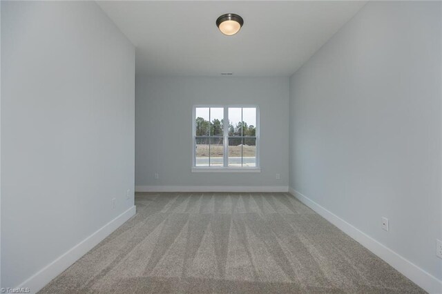 unfurnished room featuring baseboards and carpet