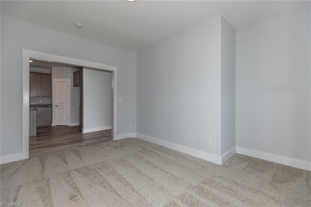 carpeted empty room featuring baseboards