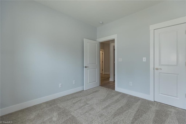 unfurnished bedroom featuring carpet flooring and baseboards