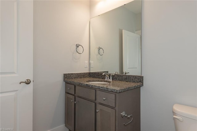 half bathroom with vanity and toilet