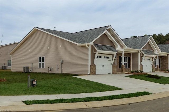 view of home's exterior with a lawn, driveway, roof with shingles, a garage, and brick siding