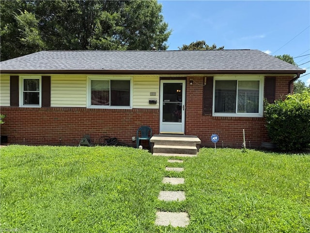 1611 Willow Rd, Greensboro, NC 27401 - view of front of house with brick siding, a front yard, and roof with shingles