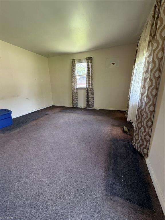 1611 Willow Rd, Greensboro, NC 27401 - empty room featuring dark carpet and baseboards