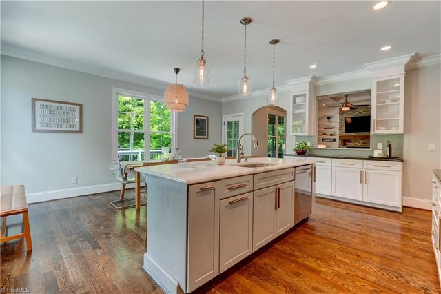 kitchen featuring stainless steel dishwasher, arched walkways, a sink, ornamental molding, and a ceiling fan