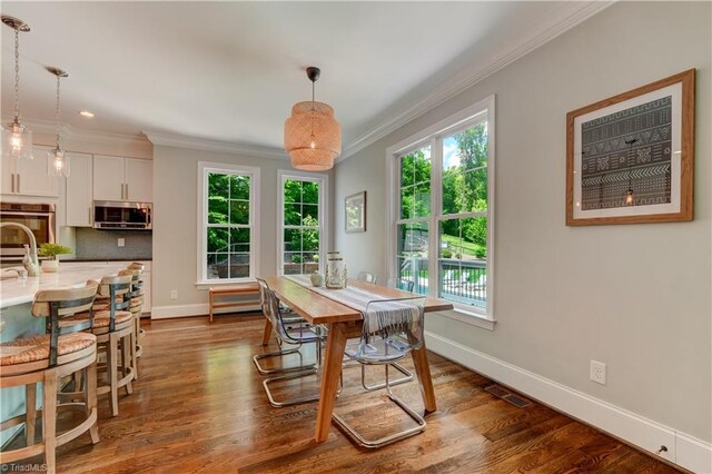 dining room featuring crown molding, plenty of natural light, baseboards, dark wood finished floors, and recessed lighting