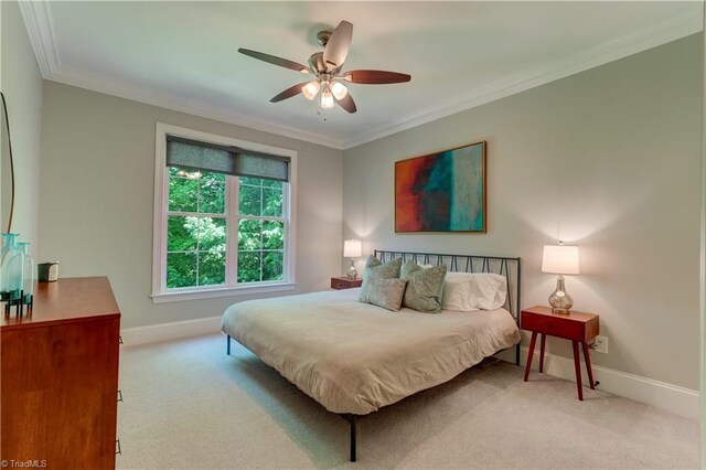 carpeted bedroom with crown molding, baseboards, and a ceiling fan