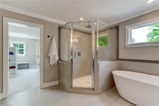 bathroom with crown molding, a stall shower, a freestanding tub, tile patterned flooring, and recessed lighting