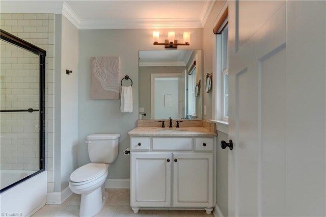 bathroom with ornamental molding, toilet, enclosed tub / shower combo, vanity, and baseboards
