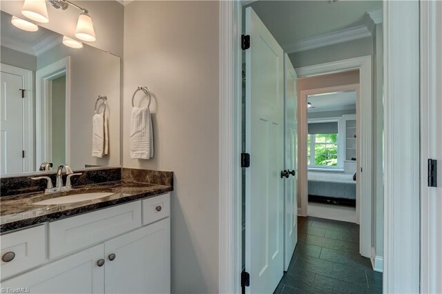 bathroom with ornamental molding, vanity, and ensuite bath