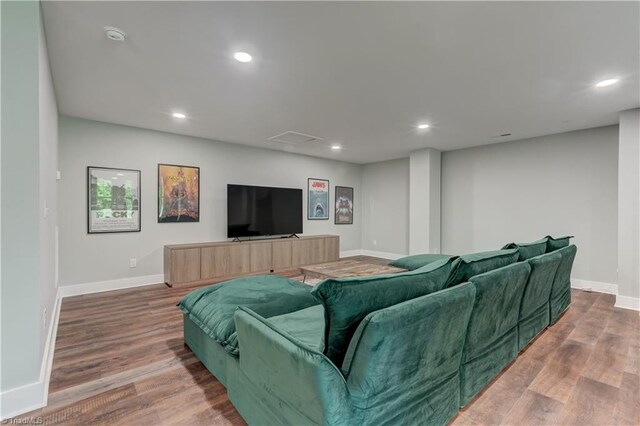 living room featuring baseboards, wood finished floors, and recessed lighting