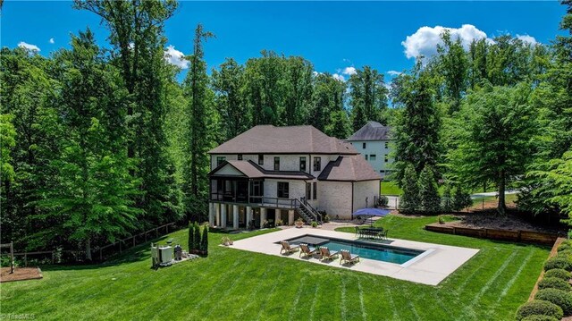 back of property with a patio area, stairway, an outdoor pool, and a sunroom