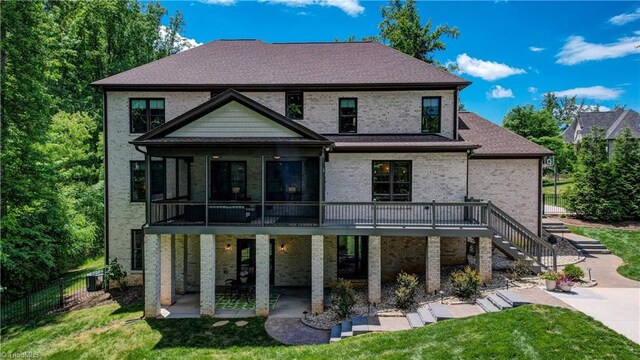 rear view of house with a patio, stairs, a deck, and brick siding