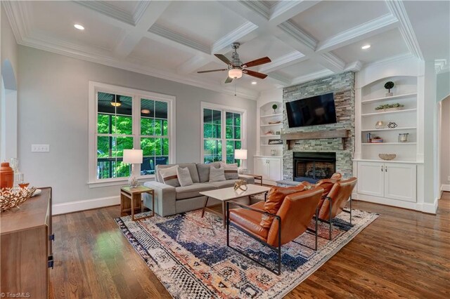 living area featuring ceiling fan, a fireplace, dark wood-style flooring, baseboards, and crown molding