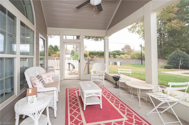 sunroom / solarium with ceiling fan and vaulted ceiling