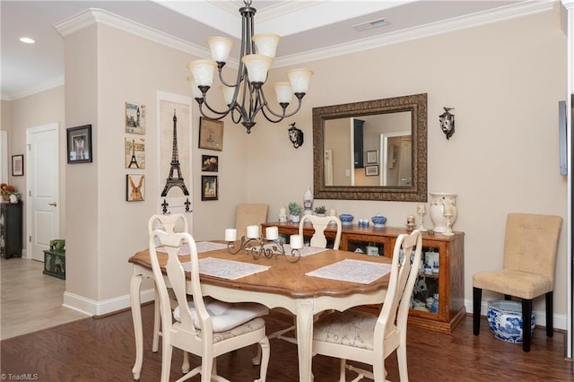 dining area featuring dark wood-type flooring, a chandelier, and ornamental molding