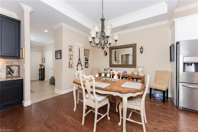 dining room with ornamental molding, dark hardwood / wood-style floors, and an inviting chandelier