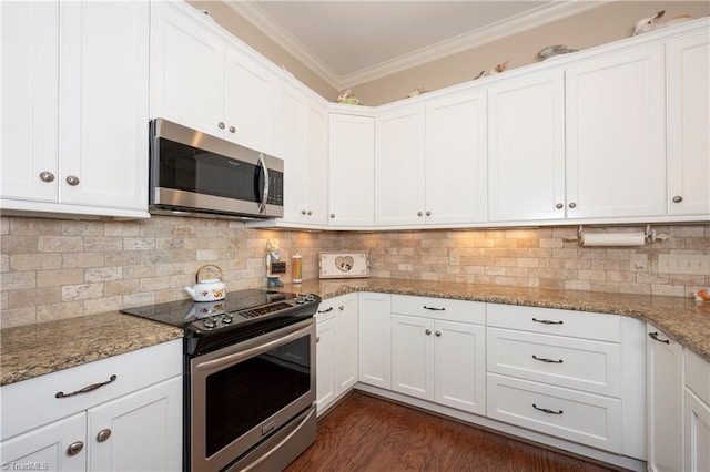 kitchen featuring light stone counters, appliances with stainless steel finishes, ornamental molding, white cabinets, and dark wood-type flooring