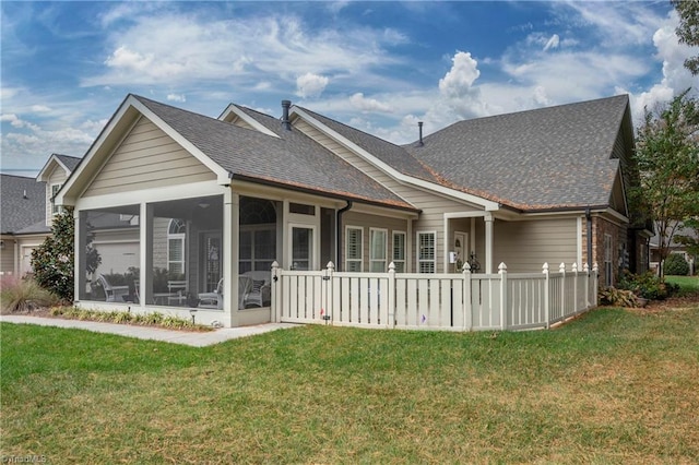 back of house featuring a lawn and a sunroom