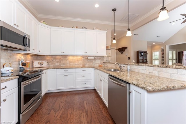 kitchen with stainless steel appliances, white cabinetry, sink, hanging light fixtures, and crown molding