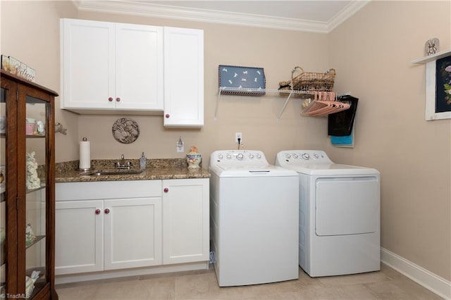 clothes washing area featuring cabinets, sink, light tile patterned floors, ornamental molding, and washer and clothes dryer