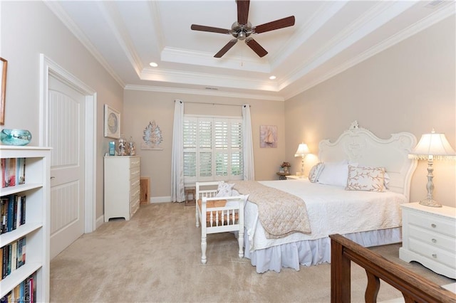 carpeted bedroom with ceiling fan, crown molding, and a tray ceiling