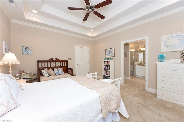 bedroom with ornamental molding, ceiling fan, a tray ceiling, and connected bathroom