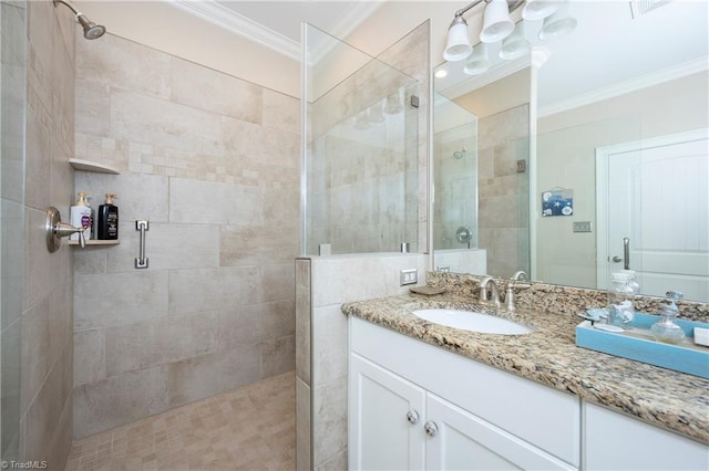 bathroom featuring vanity, a shower with door, and ornamental molding