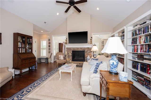 living room featuring ceiling fan, vaulted ceiling, dark hardwood / wood-style floors, and a fireplace