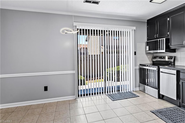 kitchen with dark cabinetry, stainless steel appliances, baseboards, and plenty of natural light