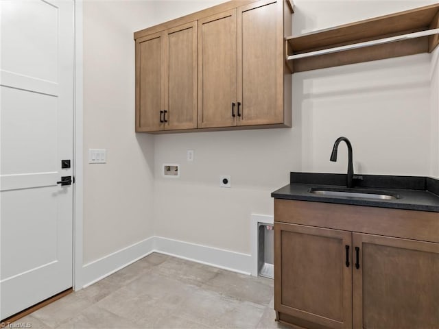 clothes washing area featuring hookup for an electric dryer, washer hookup, a sink, baseboards, and cabinet space