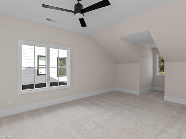 bonus room with lofted ceiling, visible vents, light carpet, ceiling fan, and baseboards