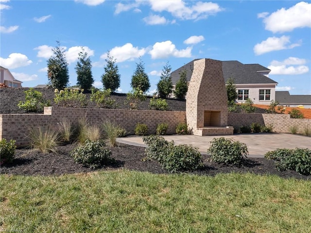 view of yard with an outdoor brick fireplace and a patio