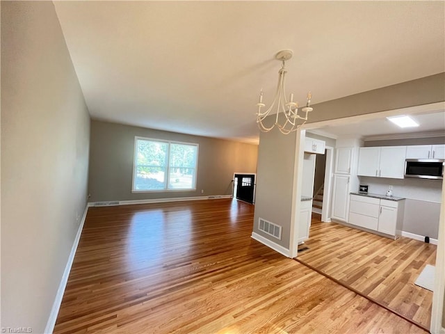 100 Petree Rd, Winston-Salem, NC 27106 - kitchen featuring stainless steel microwave, light wood-style floors, a chandelier, and white cabinets