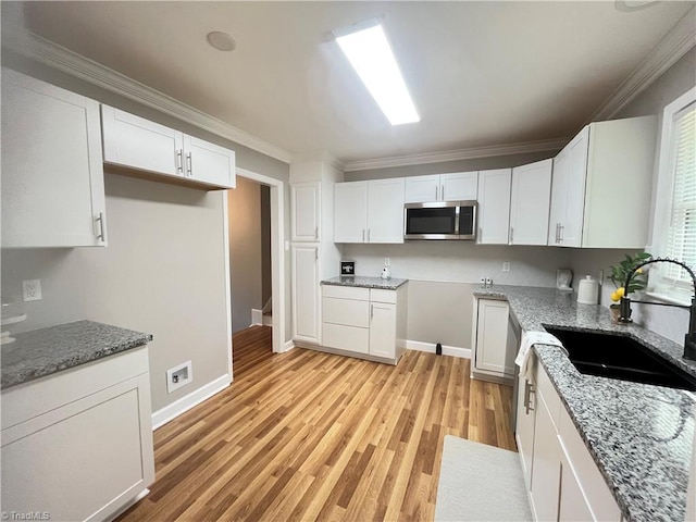 100 Petree Rd, Winston-Salem, NC 27106 - kitchen featuring light stone counters, stainless steel microwave, light wood-type flooring, ornamental molding, and white cabinets