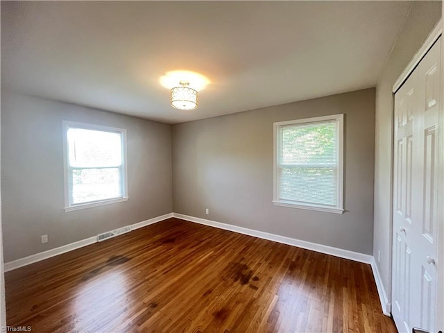 100 Petree Rd, Winston-Salem, NC 27106 - unfurnished bedroom featuring multiple windows, dark wood finished floors, and a closet