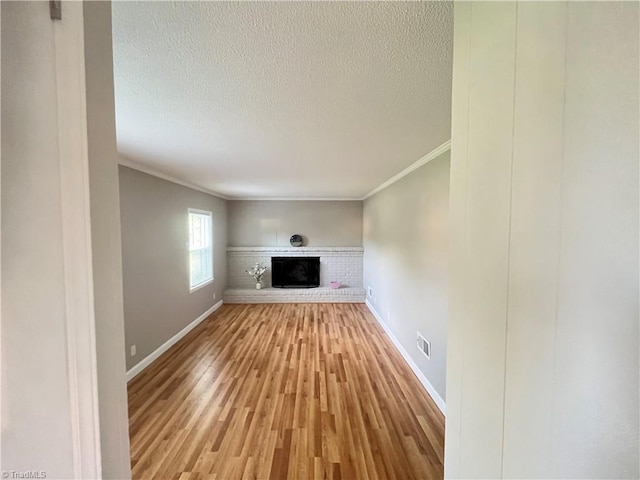 100 Petree Rd, Winston-Salem, NC 27106 - unfurnished living room with ornamental molding, a textured ceiling, light wood-type flooring, and a fireplace