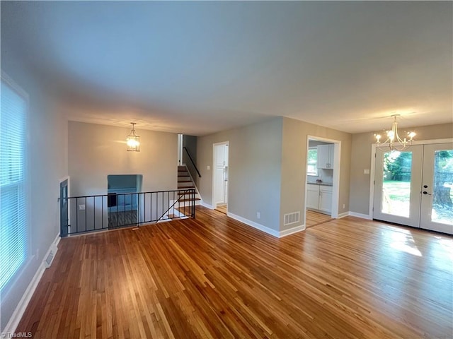 100 Petree Rd, Winston-Salem, NC 27106 - unfurnished living room with a chandelier, hardwood / wood-style flooring, french doors, and stairway