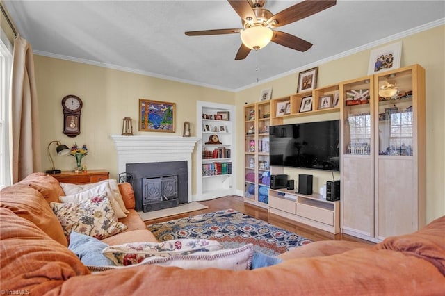 1109 Wildwood Rd NE, Lenoir, NC 28645 - living room featuring wood finished floors, ornamental molding, built in shelves, ceiling fan, and a fireplace