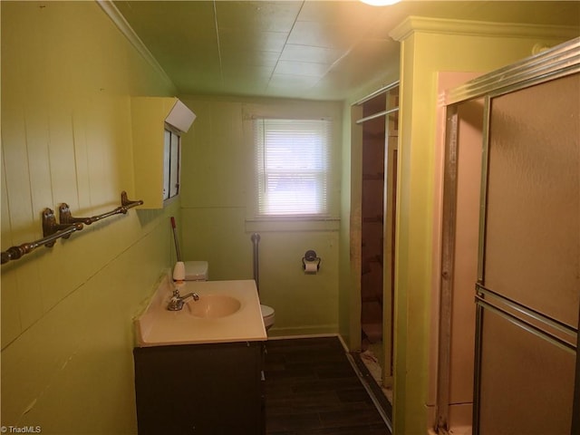 bathroom with vanity, a shower with door, crown molding, toilet, and wood-type flooring